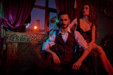 Aşık göz kamaştırıcı bir çift. Seksi siyah iç çamaşırlı güzel bir kadın ve lüks bir dairede şık takım elbiseli yakışıklı bir adam. Moda fotoğrafı.. 