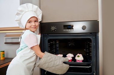Mutlu küçük kız evde mutfakta kek pişiriyor. Mutlu bir aile. Evde sağlıklı yiyecekler, tatlılar..