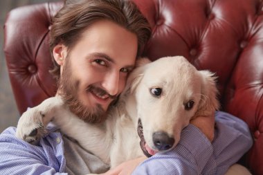 Yakışıklı genç adam evcil köpeği Golden Retriever ile vakit geçiriyor..