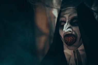 Kanlı dişleri olan şeytani korkunç bir rahibenin yakın plan portresi. Cadılar Bayramı ve Dehşet.