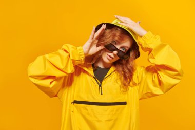 Stüdyoda sarı arka planda poz veren modern tarz dansçı kız..