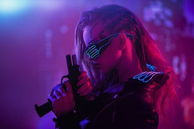 Oyun, sanal gerçeklik. Cesur bir siber punk kız savaşçısı elinde silahla geleceğin gece şehrinin zeminine dayanıyor. Siber punk kavramı.