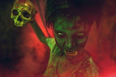 Korku ve Cadılar Bayramı. Kızgın saldırgan zombi ergen elinde kafatasıyla uğursuz kırmızı bir sis ile çevrili.. 