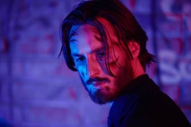 Yaralı bir aksiyon kahramanının yakın plan portresi. Yüzünde kanlı yaralar var. Şehrin çok renkli ışıklarıyla.. 