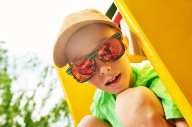 Mutlu çocuk dinleniyor ve parkta oyun parkında eğleniyor. Yaz tatili. Mutlu çocukluk.