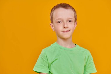 Stüdyo portresi, sarı arkaplandaki fotokopi çekilen kameraya gülümseyen sevimli bir çocuğun fotoğrafı. Çocuklar ve eğitim. 