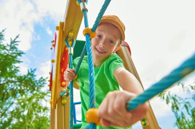 Mutlu çocuk dinleniyor ve parkta oyun parkında eğleniyor. Yaz tatili. Mutlu çocukluk.