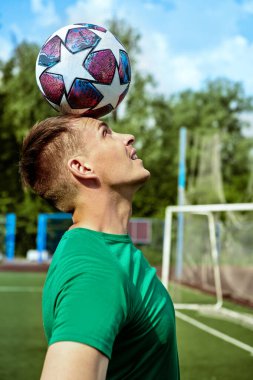Atletik adam futbol sahasında topla antrenman yapıyor. Futbolcu. Aktif yaşam tarzı, hobi. 