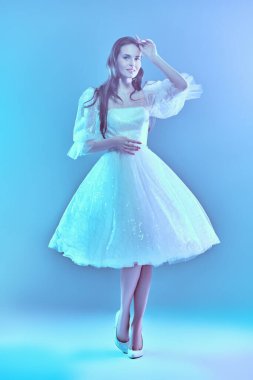 Stüdyoda zarif mavi ışıkta poz veren güzel gelinlikli güzel bir gelin kız. Tam boy portre. Düğün modası.