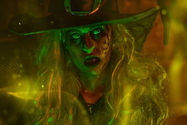 Yeşil ve sarı ışıklı korkunç çirkin cadının portresi. Cadılar Bayramı. Korkunç hikayeler.. 