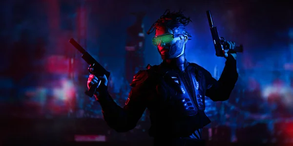A courageous cyberpunk warrior fights with guns in his hands against the backdrop of the night city of the future. Game, virtual reality. Cyberpunk concept.