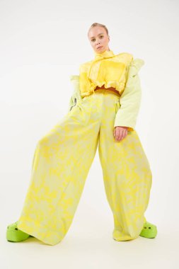 Parlak yaz tarzı. Stüdyoda şık yaz kıyafetleri içinde poz veren zarif bir kızın tam boy portresi. Beyaz arka plan. Moda fotoğrafı..