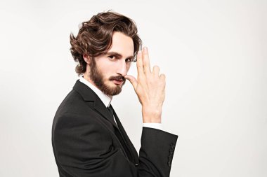 Yakışıklı erkek modeli kameraya bakarak poz veriyor. Moda konsepti. Beyaz arkaplanda stüdyo portresi. 