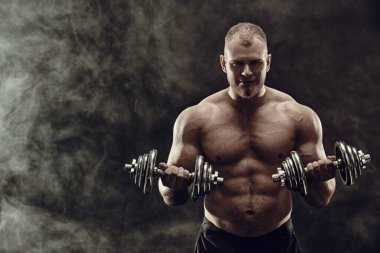 Siyah arka planda yeşil ışıklandırmalı güçlü, sağlıklı, yakışıklı bir atletin portresi. Erkek güzellik konsepti. MMA, el dövüşleri.