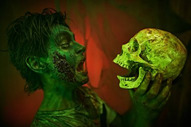 Korku ve Cadılar Bayramı. Kızgın, agresif zombi ergen elinde tutuyor ve ona bağırıyor.. 