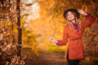 Doğada poz veren güzel genç bir kadın. Sonbahar güzelliği, moda.