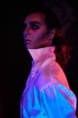 Yakışıklı genç bir aristokrat vampirin portresi. Küstahça kameraya bakıyor. Kırmızı ve mavi ışıkta..