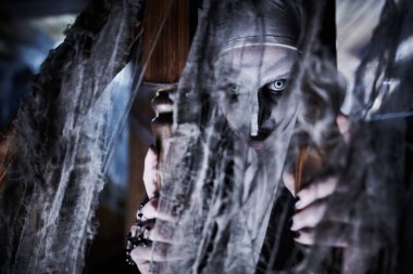 Terk edilmiş kilisede duran lanetli bir rahibenin yakın plan portresi. Korku ve Cadılar Bayramı. 