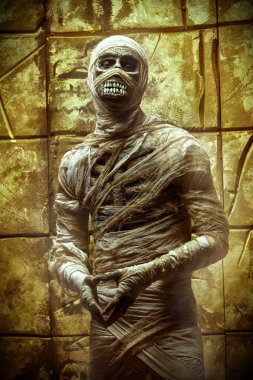 Eski Mısır hiyeroglifleri olan bir duvarın yanında duran bir mumyanın portresi. Cadılar Bayramı. Antik Mısır mitolojisi.