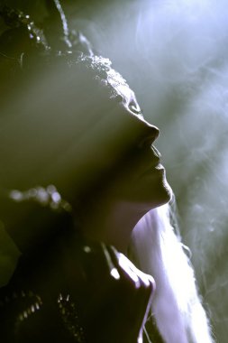 Fantezi Dünyası. Güzel, görkemli bir siyah kraliçe, zengin başlıklı bir cadı ve zengin siyah bir elbise, karanlık bir kaledeki ışığın altında duruyor..