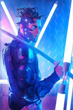 Koruyucu giysili cesur bir bilim kurgu samurayı elinde neon ışıkla savaşıyor. Siber punk dünyası. Oyun, sanal gerçeklik.