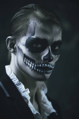 Kafatası makyajlı, zarif bir takım giyen şeytani çekici bir adamın portresi. Dia de los muertos. Ölüler Günü. Cadılar Bayramı.