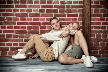 Kaygısız aşıklar. Güzel bir kız yerde sevgilisinin kollarında yatıyor ve gülüyor. Tavan arası olan bir oda..