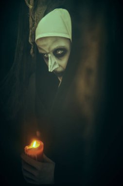 Korku ve Cadılar Bayramı. Terk edilmiş kilisede elinde mumla duran lanetli bir rahibenin portresi..