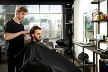 Berber dükkanında müşteriye hizmet eden bir kuaför. Yakışıklı esmer adam kuaförü ziyaret ediyor. Modern kuaför salonu.. 