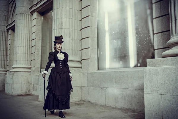 19. yüzyıldan zarif bir kadın şehir caddesinde geziniyor. 19. yüzyılın sonları - 20. yüzyılın başları. Tam boy portre.