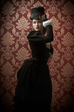 19. yüzyıl takım elbiseli zarif bir kadının portresi klasik bir arka planda poz veriyor. 19. yüzyıl moda ve güzelliği.