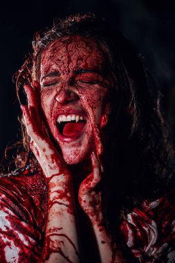 Bir vampir tarafından ısırılan, kanla kaplı, dehşet içinde çığlık atan ve vampire dönüşen bir kız. Korku, gerilim. Cadılar Bayramı. Vampirler..