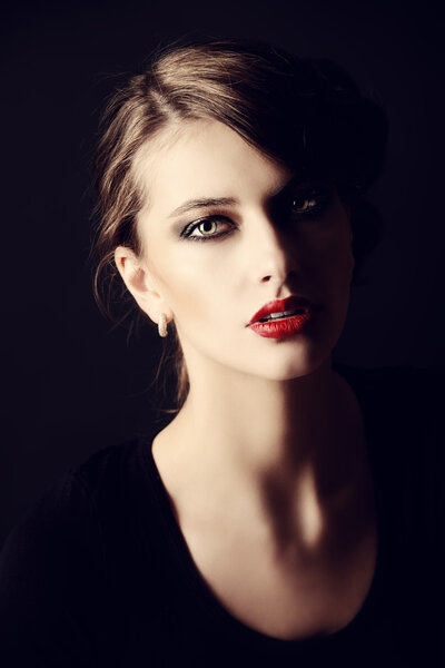 Close-up portrait of a beautiful elegant woman over black background.