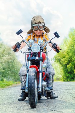 Çocuğun üstünde motosiklet