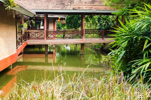Bridge over the pond in garden, pathway to residential. — Stock fotografie