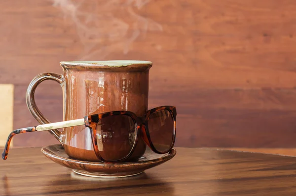 Caneca de café com óculos de sol na mesa — Fotografia de Stock