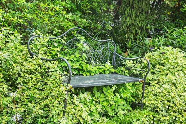 Panca sullo sfondo lussureggiante nel design del giardino inglese . — Foto Stock