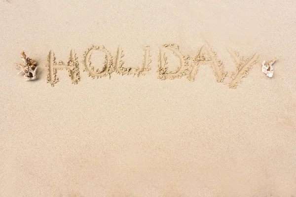 "HOLIDAY "written in the sand on the beach with copy space for t — стоковое фото