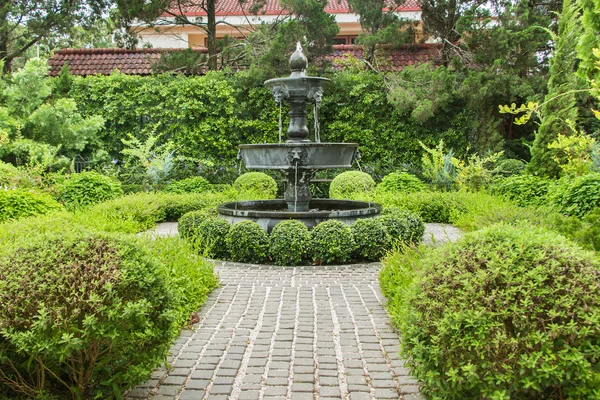 Nature background. Fountain in english garden design. Royaltyfria Stockbilder