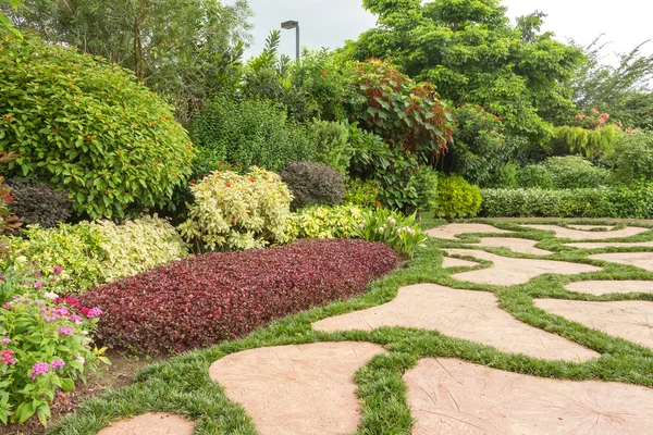 Anlagd trädgård med blomster och färgglada växter Stockfoto