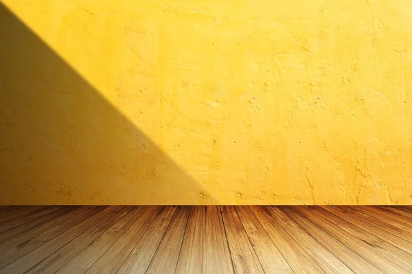 Ljusa orange betongväggen mot perspektiv trä golv med Stockfoto