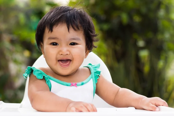 Söt baby flicka avkopplande, ler och skrattar på stol — Stockfoto