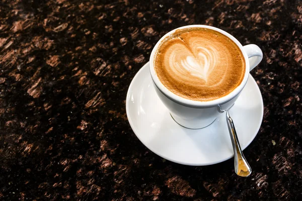 Šálek kávy na mramorový stůl. Latte art srdce tvar. — Stock fotografie