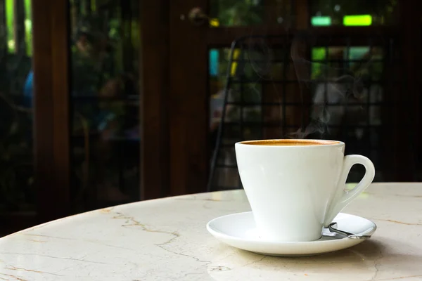 Tazza bianca di caffè sul tavolo nel caffè — Foto Stock