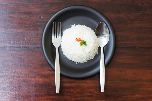 Cooked rice with a spoon and fork on dish — Stock Photo, Image