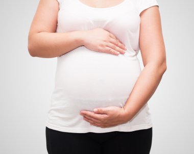 Hamile karnına kırpma pa ile beyaz arka planda tutan el