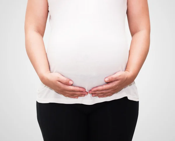 Hand holding pregnant belly on white background with clipping pa — Stock Photo, Image