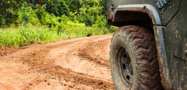 Araba tekerlekleri yuvarlak toprak yolda gitmek.