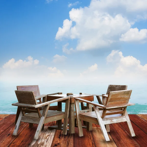 Набор деревянных столов на полу против пляжа . — стоковое фото