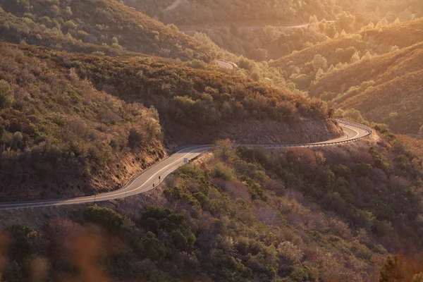 Vento curvas estradas através das montanhas em um pôr do sol — Fotografia de Stock